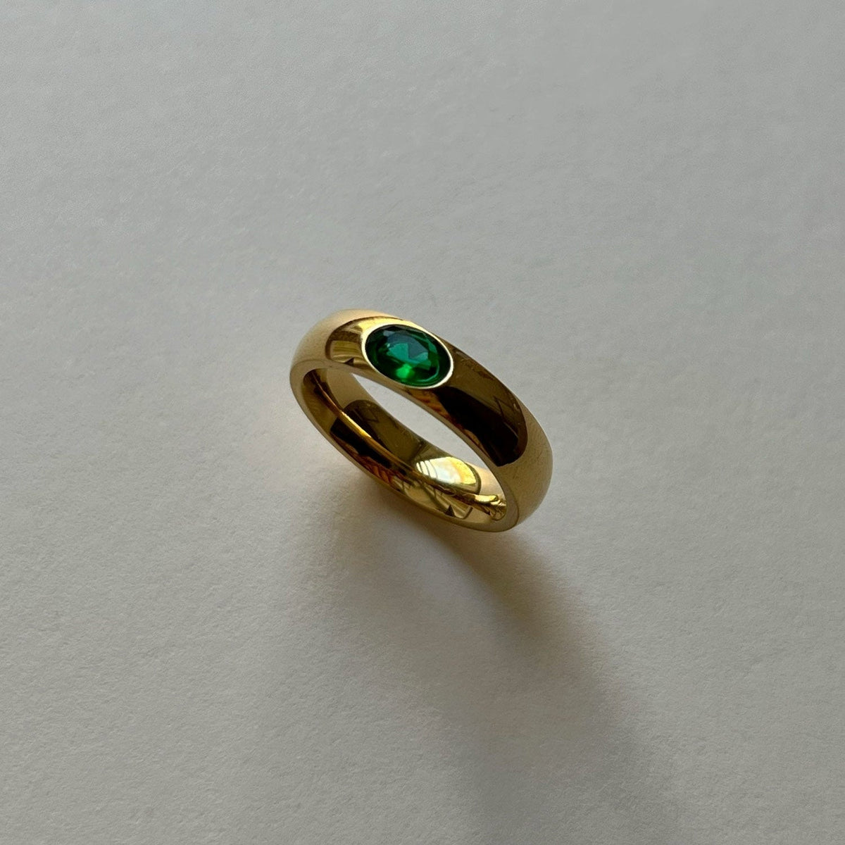 Gold ring featuring a sparkling green gemstone