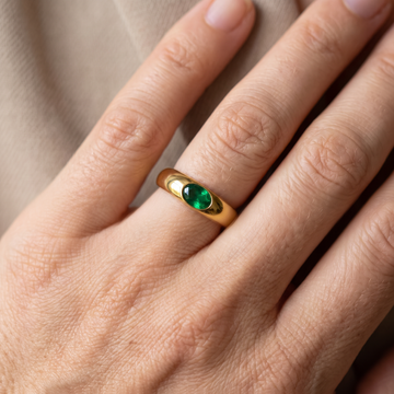 Gold ring featuring a sparkling green gemstone