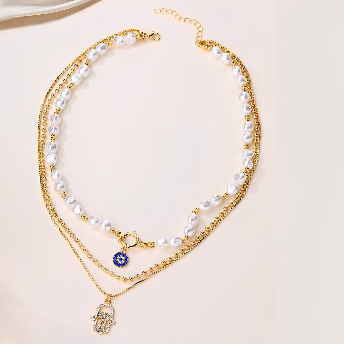 Nadia – Multi-Strand Pearl Necklace with Hamsa Hand